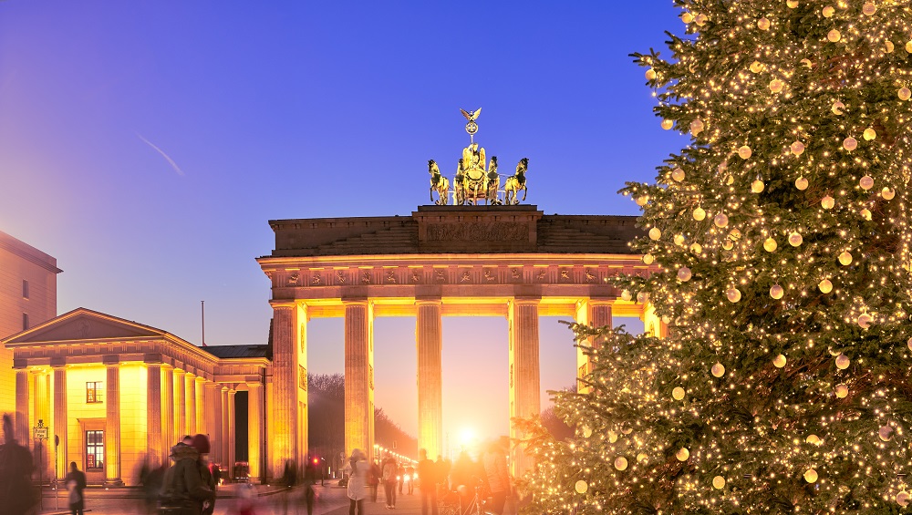 Panoramic image of Brandenburger Gate in Berlin with Christmas tree on a sunset with evening illumination.