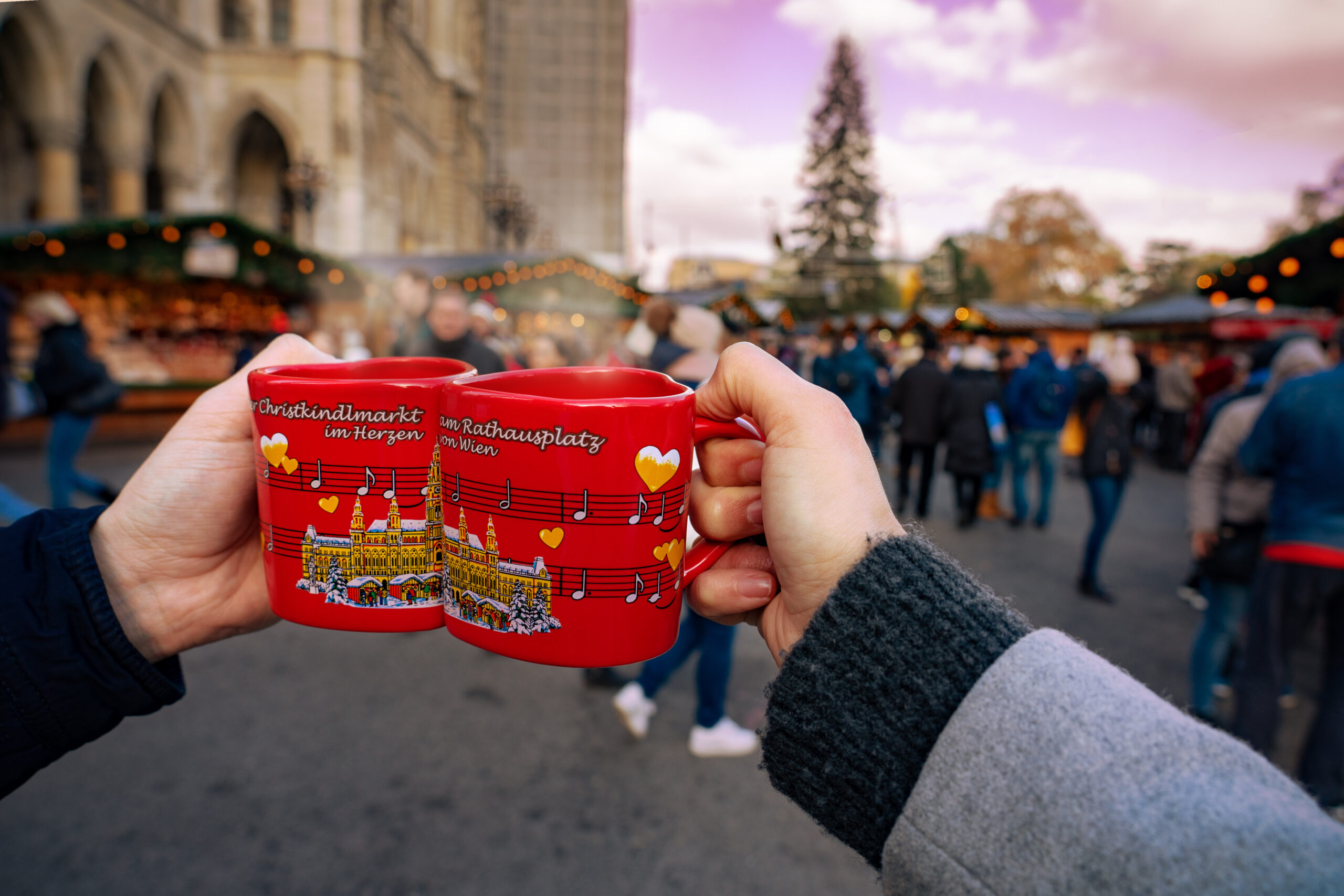 Vienna, Austria - 11.23.2019 : Drinking gluwein hot alcoholic spicey red wine on christmas market cups on the rathausplatz in Vienna